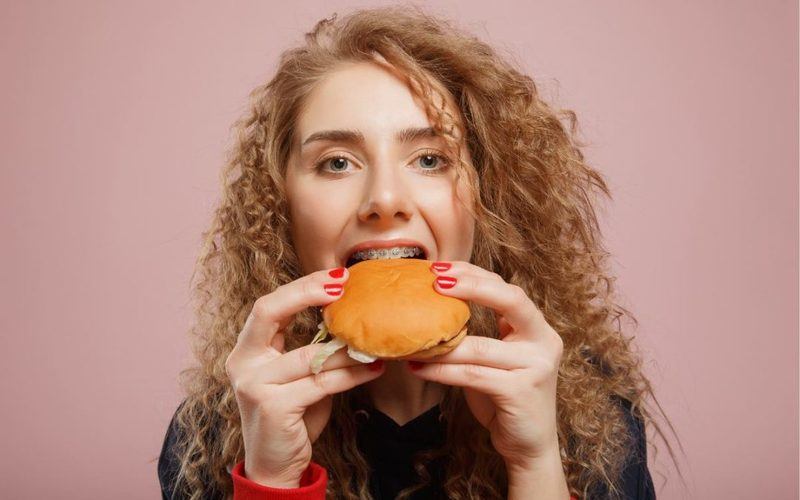 Woman with braces eating a sandwich